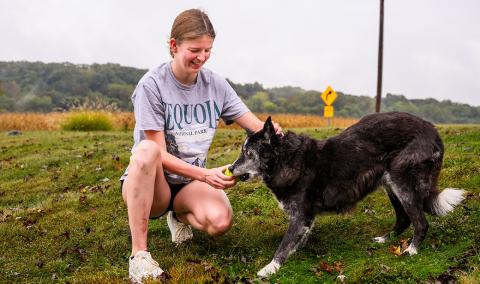 A girl playing with her dog outdoors.