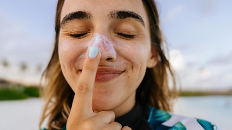 woman putting on sunscreen
