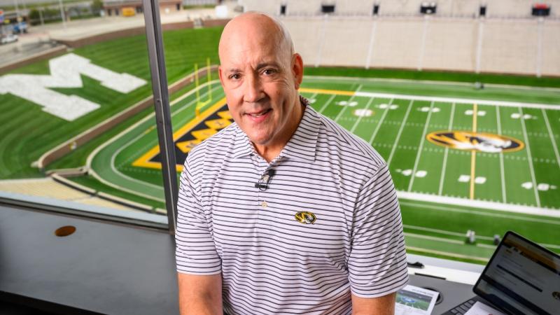 Man standing in a sports stadium box suite.