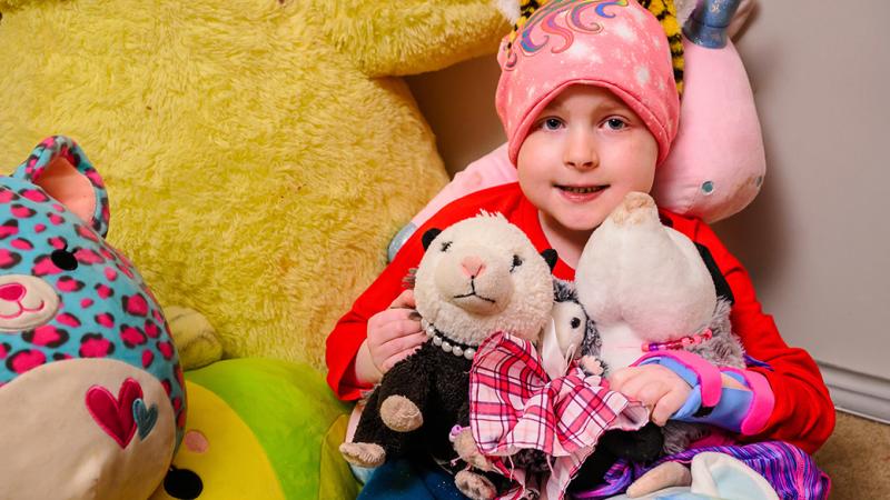 A photo of a child with stuffed animals.