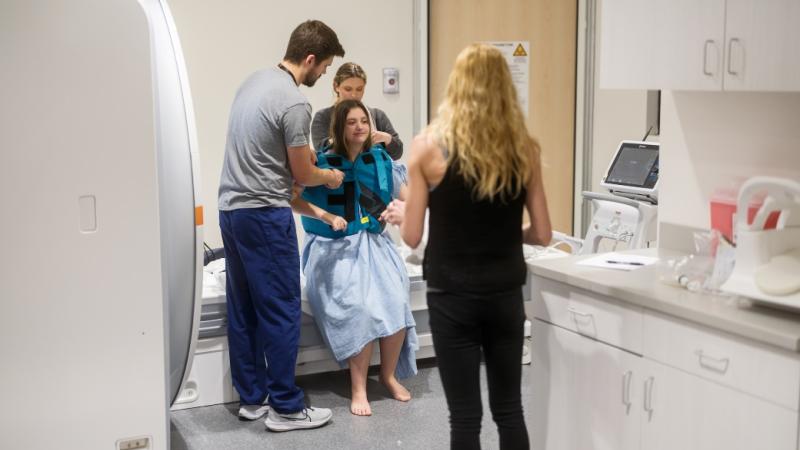Health care workers helping a female patient.