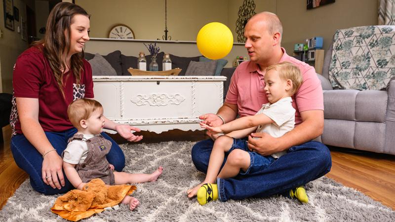 A picture of a family sitting on the floor of their living room.
