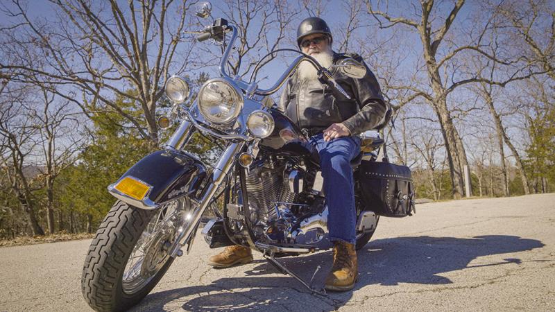 A photo of a man on a motorcycle.