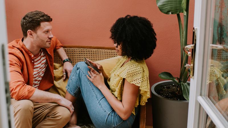 A man and a woman sitting on a sofa.