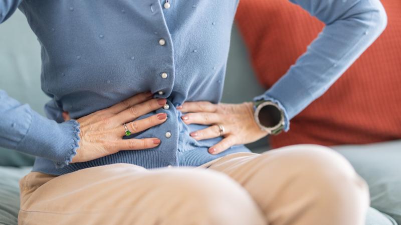 A photo of a person gripping their stomach.