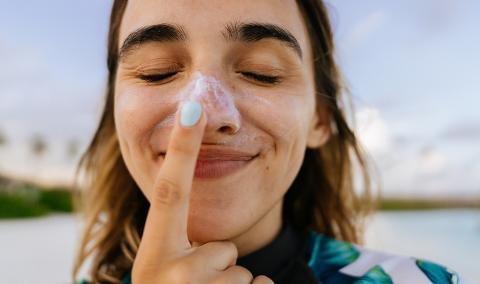 woman putting on sunscreen