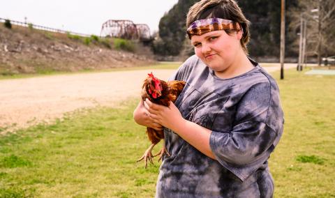 A photo of Caitlynn holding a chicken.