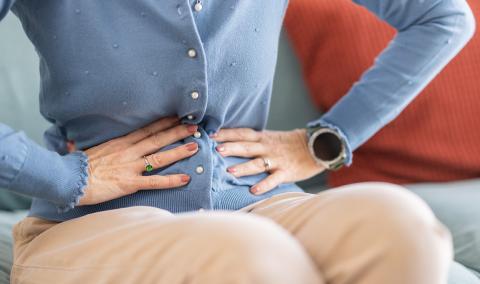 A photo of a person gripping their stomach.