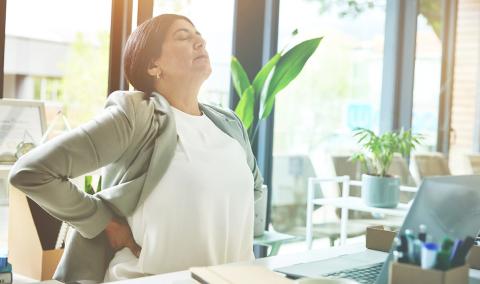 A woman rubbing her back.