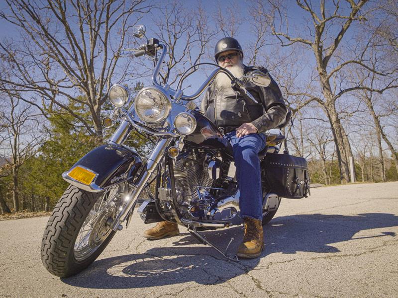 A photo of a man on a motorcycle.